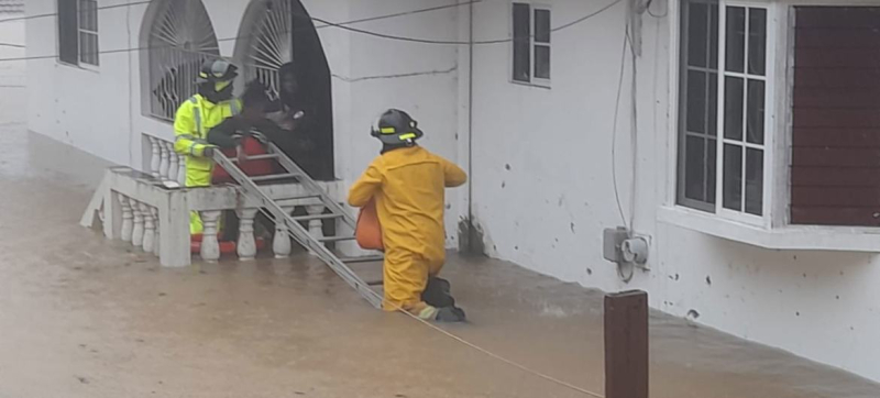 Спасатели помогают жителям Ямайки эвакуироваться.