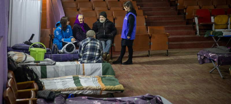 Сотрудники УВКБ разговаривают с переселенцами из Донецкой области в транзитном центре.