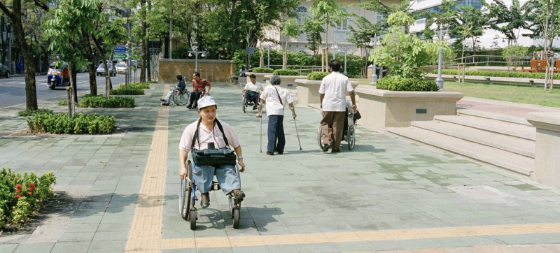 Парк в Бангкоке, Тайланд, где были установлены вспомогательные устройства для людей с инвалидностью, включая направляющие и предупреждающие знаки.